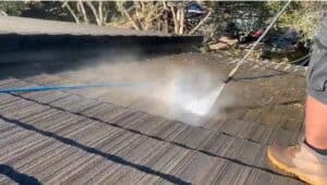 cleaning the mud and dried leaves of the roof as part of the Home Power Washing Services of Power washing Pro